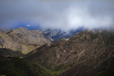 Mountain landscape with sea and ship partly covered by clouds Tenerife Spain