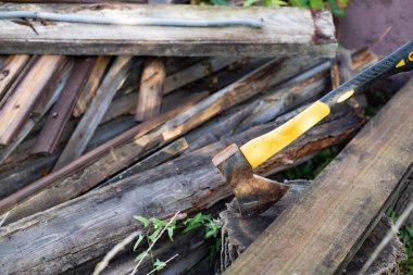 Tahtaya saplanmış sarı saplı balta. El işçiliği ve ahşap işçiliği kavramı.