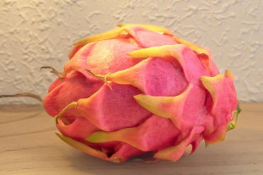 Tahta masa üzerinde pembe kabuklu taze ejderha meyvesi. Vitamin ve antioksidan açısından zengin egzotik tropikal meyve..