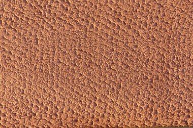 Güneş ışığıyla aydınlatılan turuncu, pürüzlü alçı duvar..