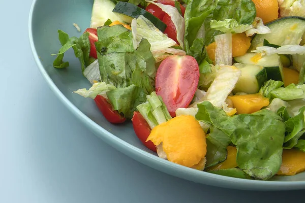 Sağlıklı sebze salatası, salatalık, dolmalık dolma biber ve domates, mavi bir kasede servis edilir..