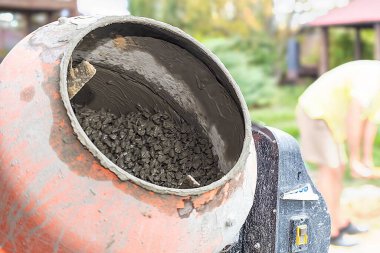 İnşaat alanında çakıllı beton karıştırıcı, inşaat sembolü, inşaat malzemeleri ve el işçiliği. Endüstriyel, mühendislik ve tasarım temaları için uygun.