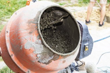 İnşaat alanında çakıllı beton karıştırıcı, inşaat sembolü, inşaat malzemeleri ve el işçiliği. Endüstriyel, mühendislik ve tasarım temaları için uygun.