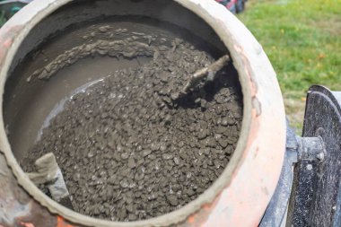 İnşaat alanında çakıllı beton karıştırıcı, inşaat sembolü, inşaat malzemeleri ve el işçiliği. Endüstriyel, mühendislik ve tasarım temaları için uygun.