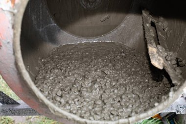 İnşaat alanında çimento karıştırıcının içinde dönen ıslak beton karışımı. İnşaat, inşaat malzemeleri, sanayi ve el işi kavramı.