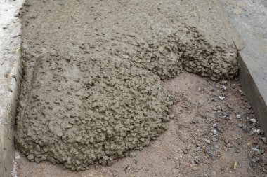 İnşaat alanında zemine ıslak beton karışımı dökülmüş. İnşaat malzemeleri, vakıf ve sanayi çalışmaları kavramı.