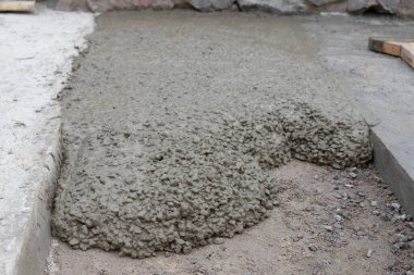 İnşaat alanında zemine ıslak beton karışımı dökülmüş. İnşaat malzemeleri, vakıf ve sanayi çalışmaları kavramı.