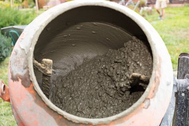 İnşaat alanında çimento karıştırıcının içinde dönen ıslak beton karışımı. İnşaat, inşaat malzemeleri, sanayi ve el işi kavramı.