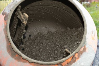 İnşaat alanında çimento karıştırıcının içinde dönen ıslak beton karışımı. İnşaat, inşaat malzemeleri, sanayi ve el işi kavramı.