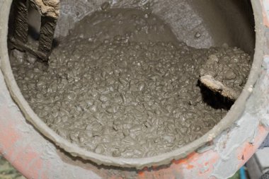 İnşaat alanında çimento karıştırıcının içinde dönen ıslak beton karışımı. İnşaat, inşaat malzemeleri, sanayi ve el işi kavramı.