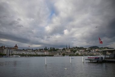 Lucerne, İsviçre 15 Temmuz 2025: Pedallı tekneler, bulutlu gökyüzü ve arka planda İsviçre Alpleri ile Lucerne Gölü manzarası. 