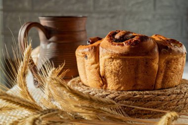 Kuru üzümlü ev yapımı tatlı ekmek ve buğday kulaklı kil sürahi.