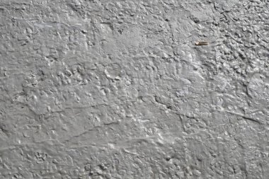 Küçük taşlar ve pürüzlü doğal yüzeyi olan nemli gri kil.