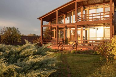 Sonbahar kırsalında geniş pencereli modern ahşap ev