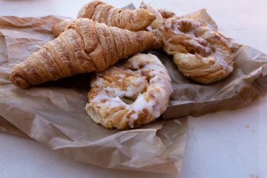 Kahvaltıda taze kruvasan ve kahverengi el işi kağıt üzerine puf böreği.