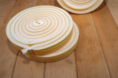 Termal yalıtım köpüğü. Ev onarımı için ahşap yüzeye yerleştirilmiş şerit ruloları.