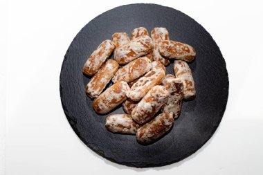 Tatlı sunumu için siyah yuvarlak tabağa dizilmiş buzlu zencefilli kurabiyeler.