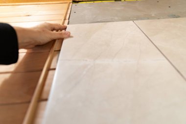 Ev yenileme işlemi sırasında seramik döşeme fayanslarının yapıştırıcıya yerleştirilmesi