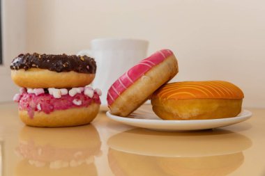 Masada kahve fincanı olan renkli donutlar tatlı bir tatlı atmosferi yaratıyor.