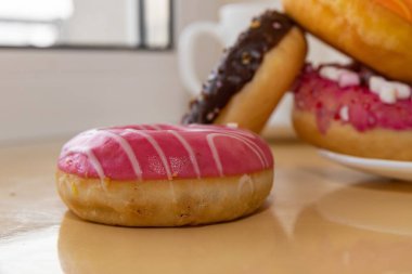 Masada kahve fincanı olan renkli donutlar tatlı bir tatlı atmosferi yaratıyor.
