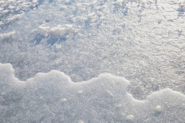 Işıl ışıl kar kristalleri ile donmuş buz yüzeyi doğal kış dokusu arka planı oluşturuyor.