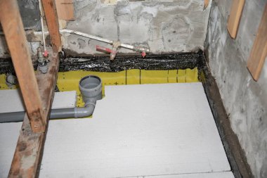 İzolasyon drenaj boruları ve su geçirmez katmanı olan banyo zeminini yenileme.