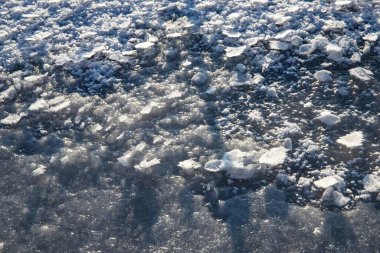 Işıl ışıl kar kristalleri ile donmuş buz yüzeyi doğal kış dokusu arka planı oluşturuyor.