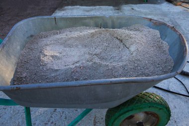 Yüzey hazırlıkları sırasında inşaat alanında kuru beton karışımıyla dolu el arabası.