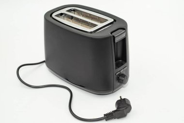 Beyaz arka plan mutfak aletlerinde elektrik kablosu olan siyah elektrikli tost makinesi.