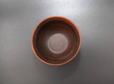 Koyu arkaplan yüzeyinde yukarıdan görünen kırsal desenli ahşap kase.