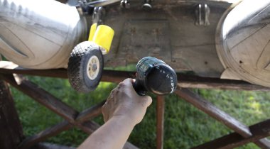 Açık hava tekne tamir işlemleri sırasında ahşap destek yapısında elektrikli matkap kullanılıyor.