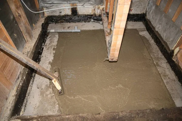 İnşaat sırasında tamamlanmamış odada yeni beton döşeme.