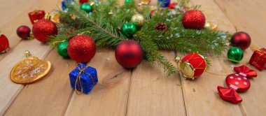 Noel süsleri köknar dalları ve ahşap şenlik arka planında renkli süsler.