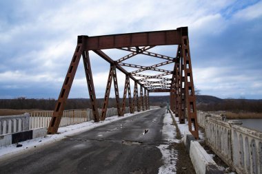 Kış havası ve kırsal manzaralı nehir manzaralı paslı metal yol köprüsü