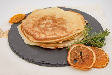 Kurumuş portakallı ve köknar dallı ev yapımı krep yığını.