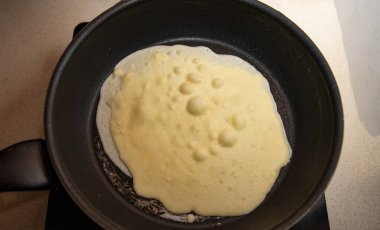 Kahvaltı hazırlama sürecinde sıcak tavada krep hamuru pişirme