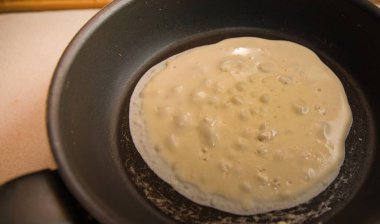 Kahvaltı hazırlama sürecinde sıcak tavada krep hamuru pişirme