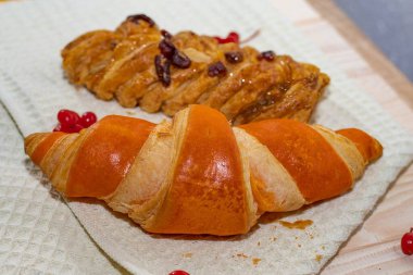 Çörekli taze hamur işleri ve waffle mutfak havlusu arka planında örülmüş tatlı çörek.