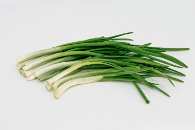 Taze taze taze taze taze soğanlar, sağlıklı besin hazırlığı için beyaz arka planda düzenlenmiştir.