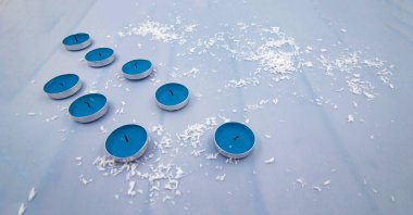 Dekoratif karlı mavi çaydanlık mumları mevsimlik tasarım için sakin kış arkaplanı oluşturuyor