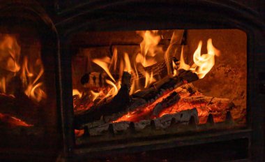 Köy şöminesinin içinde parlayan parlak alevlerle yanan odun.