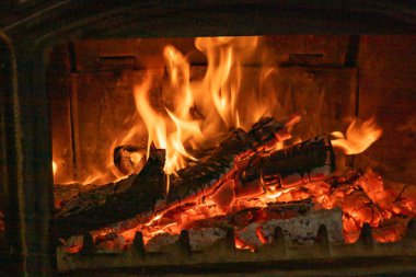 Köy şöminesinin içinde parlayan parlak alevlerle yanan odun.