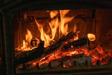 Köy şöminesinin içinde parlayan parlak alevlerle yanan odun.