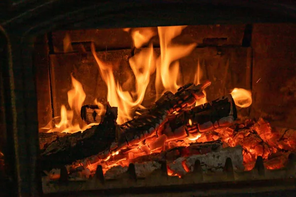 Köy şöminesinin içinde parlayan parlak alevlerle yanan odun.