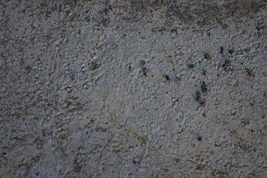 Doğal dokusu ve yıpranmış gri endüstriyel arka planı olan pürüzlü beton duvar yüzeyi.