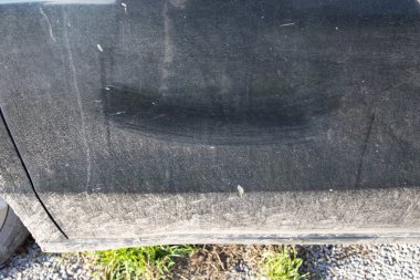 Yolda sürdükten sonra çizik ve kirli dokularla kirli araba yüzeyi.