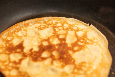 Kızartma tavasında pişen altın krep desen ve kahverengiyi gösteriyor