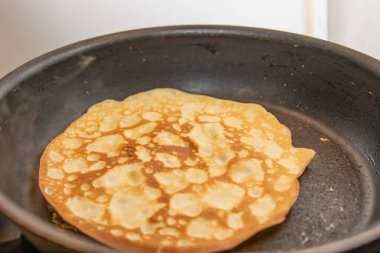 Kızartma tavasında pişen altın krep desen ve kahverengiyi gösteriyor