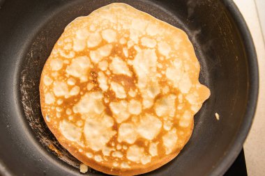 Kızartma tavasında pişen altın krep desen ve kahverengiyi gösteriyor