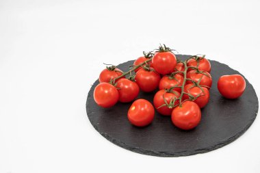 Üzüm üzümlü kiraz domatesleri siyah tahta üzerinde izole edilmiş beyaz arka plan